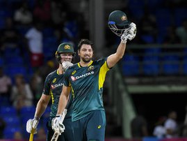 Tim David (R) of Australia celebrates his century and teammate Mitchell Owen (L) cheer him on during the third Twenty20 (T20) international cricket match between West Indies and Australia