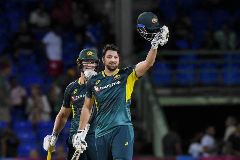 Tim David (R) of Australia celebrates his century and teammate Mitchell Owen (L) cheer him on during the third Twenty20 (T20) international cricket match between West Indies and Australia