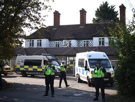 Police officers stand outside the The Bell Hotel, believed to be housing asylum seekers, in Epping, northeast of London