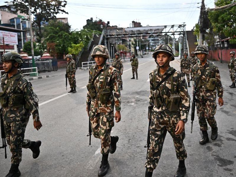 Nepal army personnel patrol along a street