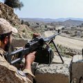 A Taliban security personnel stands guard along a road near the Ghulam Khan zero-point border crossing between Afghanistan and Pakistan