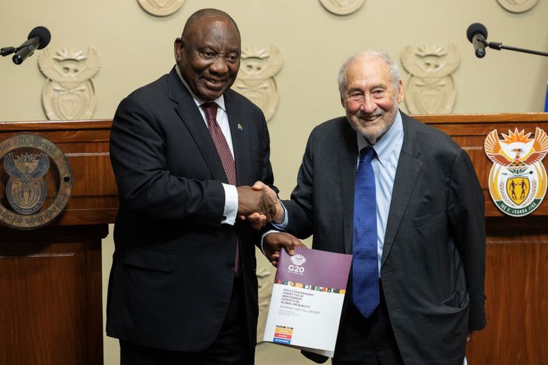 US economist and recipient of the Nobel Prize in Economic Sciences Joseph Stiglitz (R) hands over the G20 Inequality Committee's Report on global inequalities to South Africa's President Cyril Ramaphosa