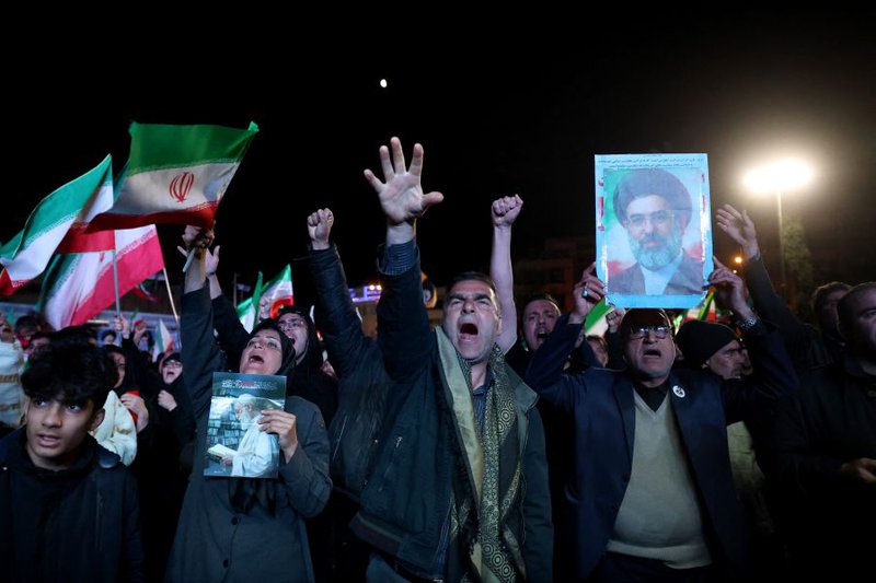 Iranians react after a ceasefire announcement at the Enqelab square, in Tehran