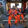 NASA astronauts Victor Glover and Christina Koch aboard a Navy helicopter after Orion splashdown recovery