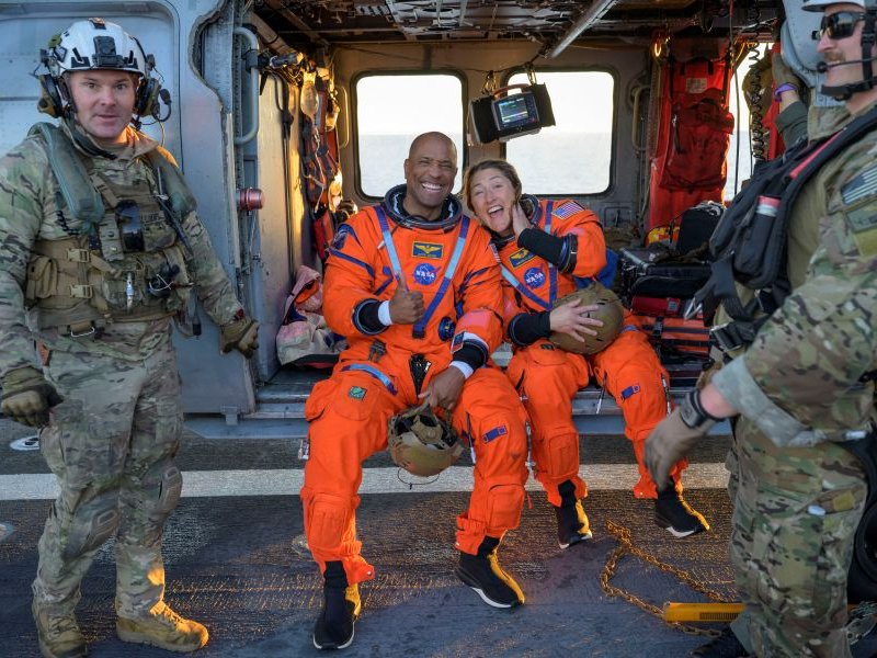 NASA astronauts Victor Glover and Christina Koch aboard a Navy helicopter after Orion splashdown recovery