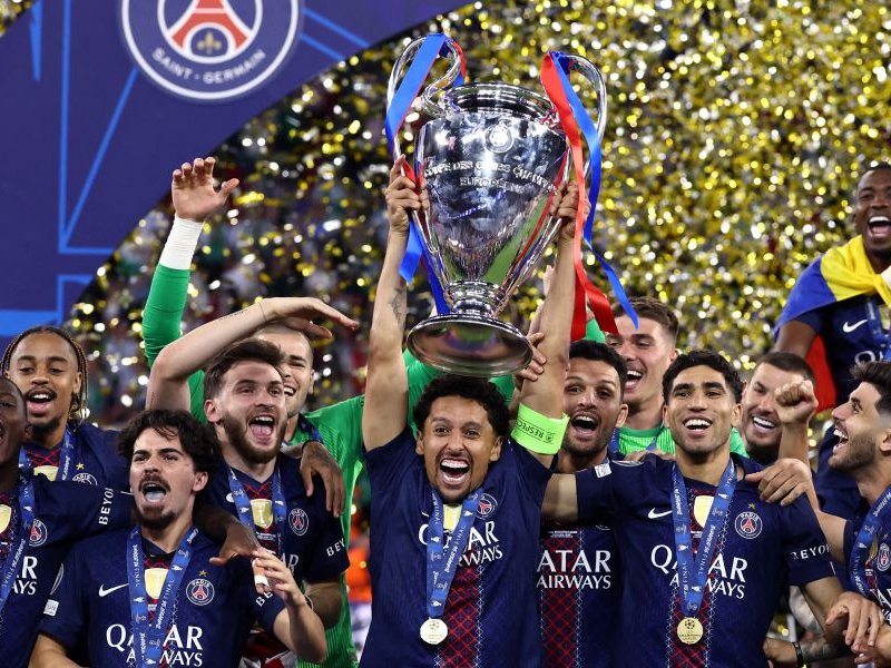 Paris Saint-Germain's Brazilian defender #05 Marquinhos lifts the trophy as he celebrates with teammates winning the UEFA Champions League final football match