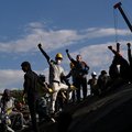 Volunteers ask for silence with their fist up as they search for survivors