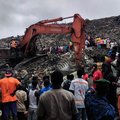 Residents and rescuers use an excavator to search for bodies after a landslide struck the Dar es Salaam dumpsite overnight