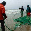 Small-scale fishermen hold a net