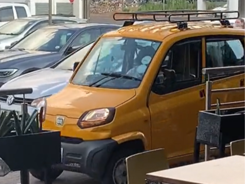A Bajaj Qute car pulling into a car park