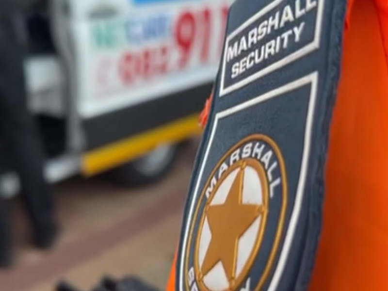 A Security officer security badge in front of an ambulance