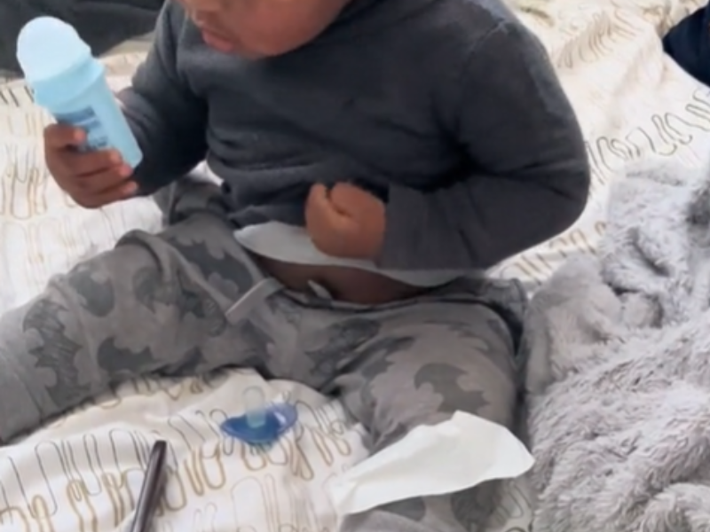 A baby boy using roll on
