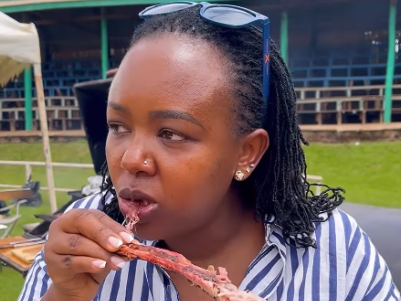 A black woman eating meat at a braai