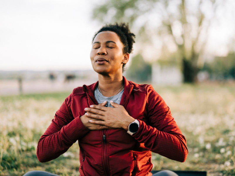 A black woman practising breathing and meditation outdoors