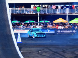 A blue old school BMW does donuts at a car show in Durban