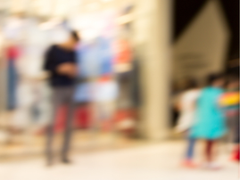 A blurred image of a man standing around children in a public space