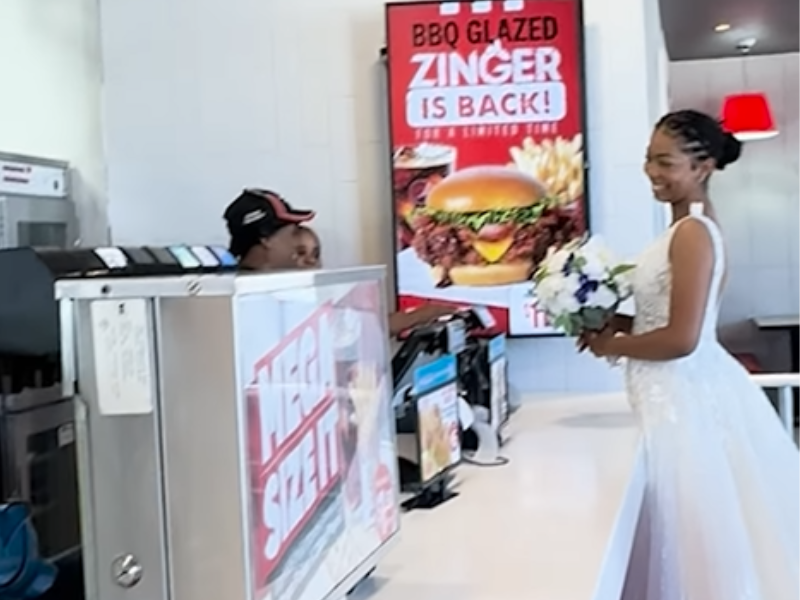 A bride smiles at the workers inside a KFC