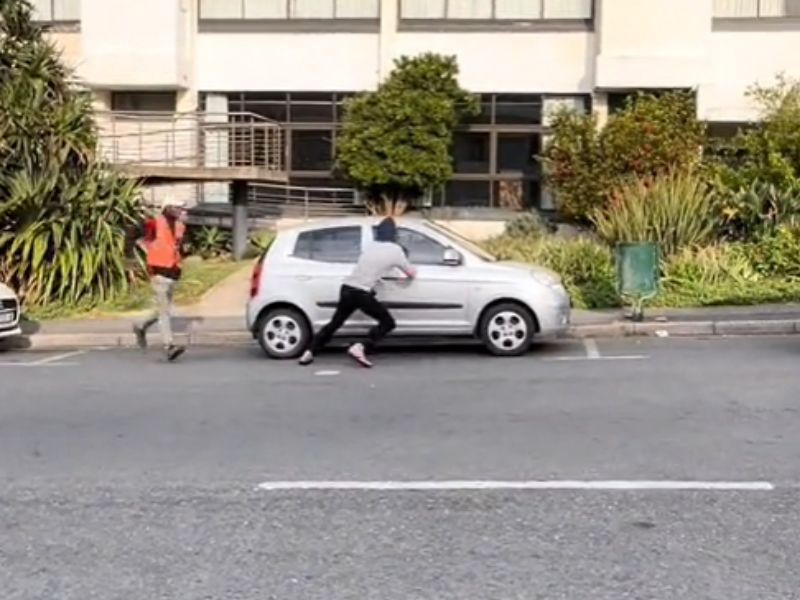 A car guard in South Africa chases after a man trying to steal a car