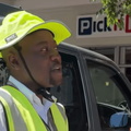A car guard talking to someone outside a Pick n Pay store