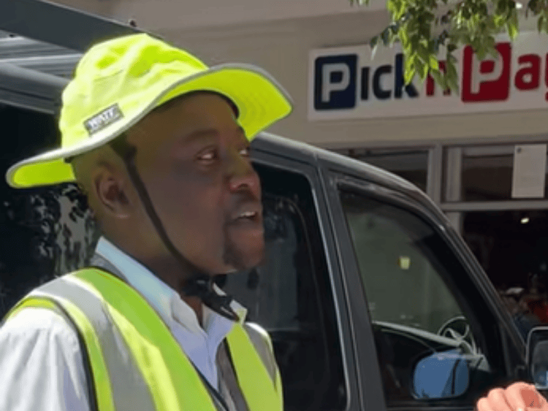 A car guard talking to someone outside a Pick n Pay store