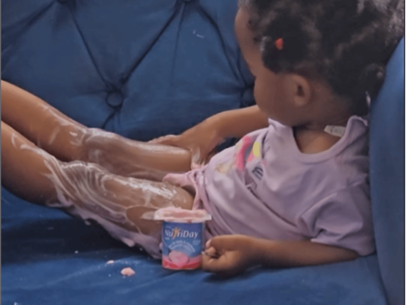 A child lathering her legs with yoghurt