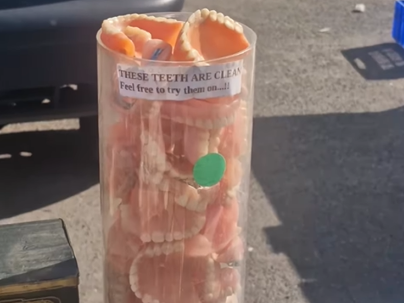 A container full of false teeth being sold at a stall