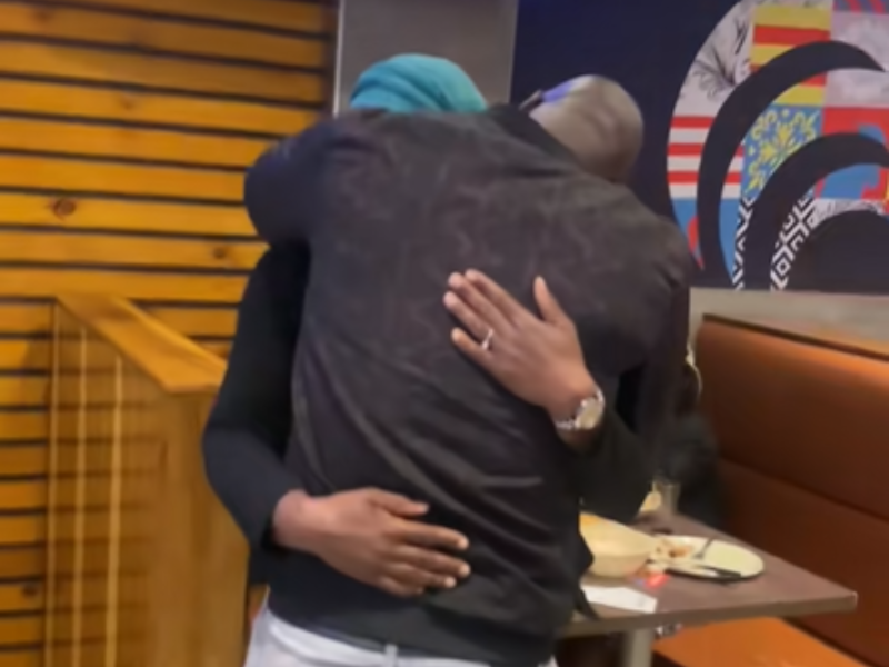 A couple embrace after getting engaged at a restaurant