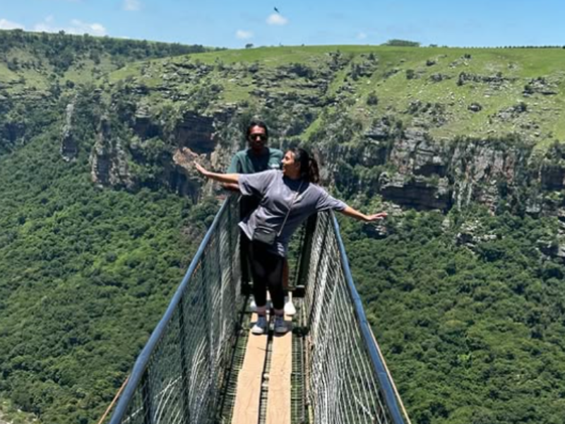 A couple stand on a suspended bridge in Oribi Gorge