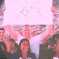 A couple with a sign on the jumbotron at a Coldplay concert