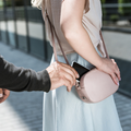 A criminal pickpocketing a smartphone from a womans handbag