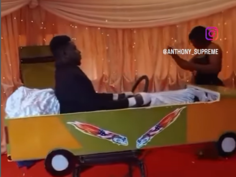 A dead man sits upright inside a taxi coffin