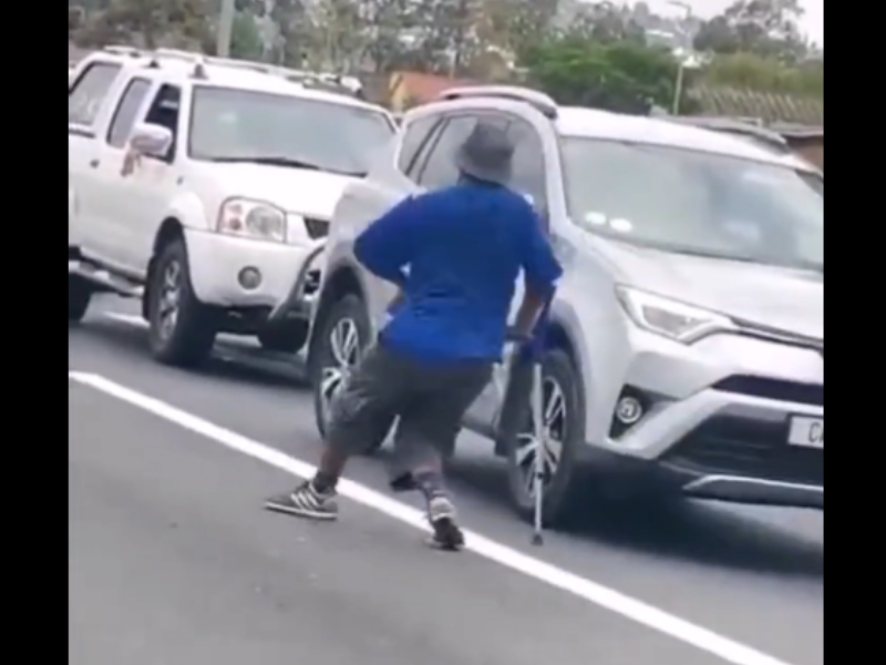 A disabled man walks in traffic