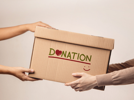 A donation box is being handed over to a volunteer