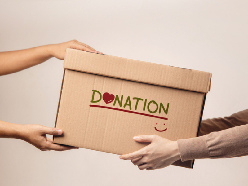 A donation box is being handed over to a volunteer