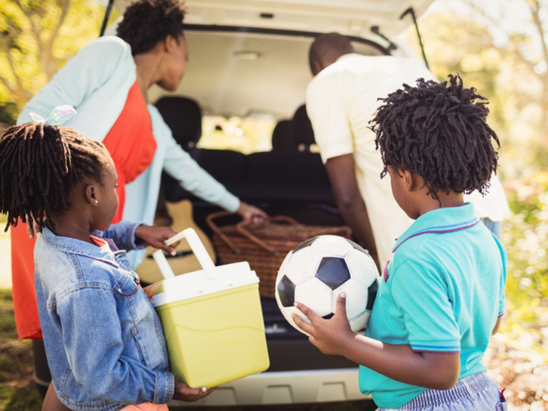 A family packing stuff into their vehicle before a trip