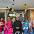 A family sit together on their patio for a welcome home party