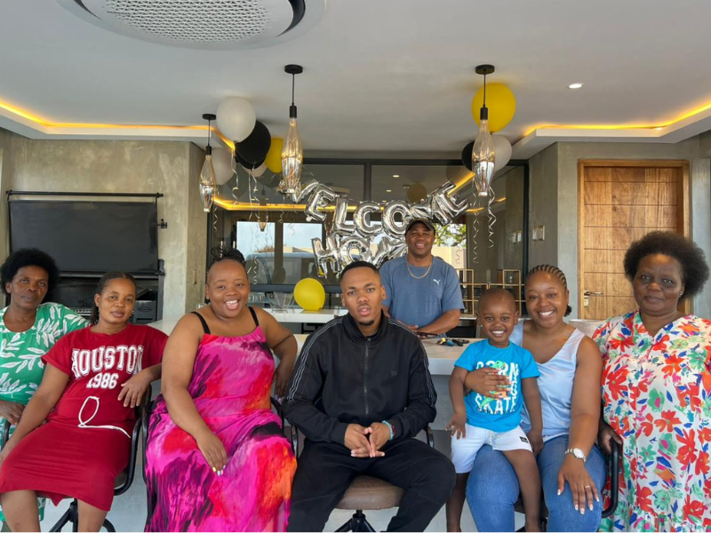 A family sit together on their patio for a welcome home party