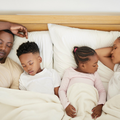 A family sleeping in bed together