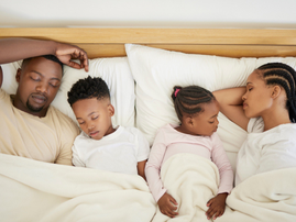 A family sleeping in bed together