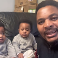 A father sits with his twin identical babies