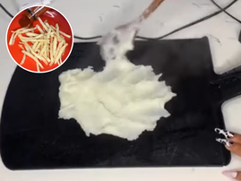 A female hand spreads pap onto a chopping board and makes pap fries