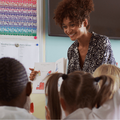 A female teacher smiles while teaching her students in the classroom
