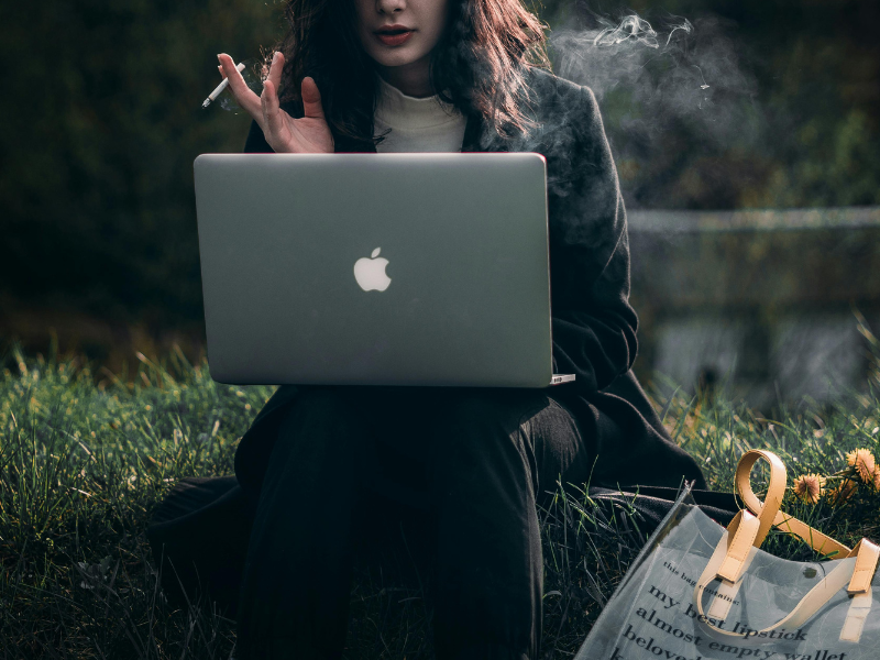 A female working on her laptop smoking