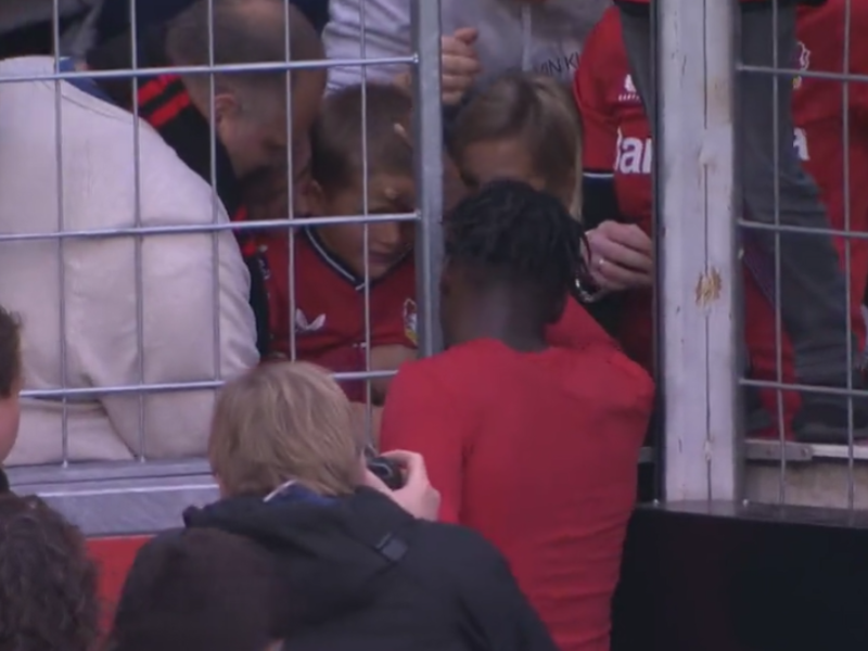 A footballer visits the fan stands rubs young boy's head