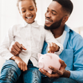 A girl holds a piggy bank with her father