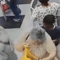 A girl steals something out of an elderly womans handbag at a grocery store