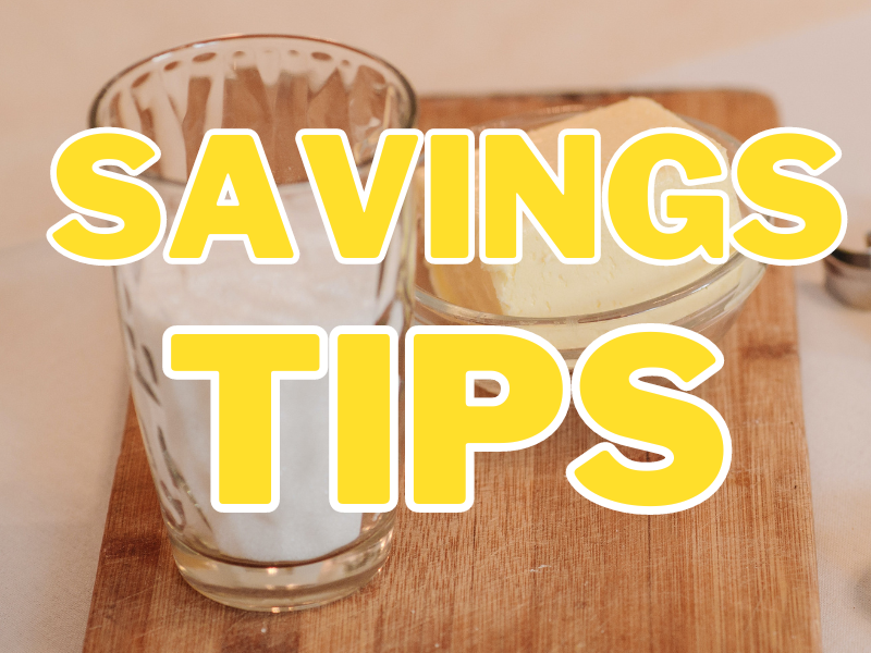 A glass of milk beside butter in a bowl on wooden surface