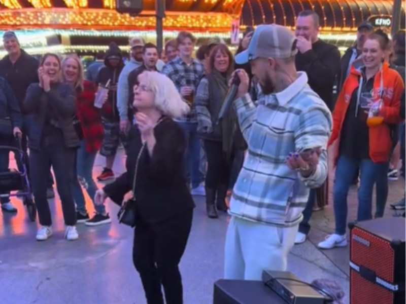 A grandmother dances to a freestyle performer on a sidewalk in Las Vegas