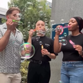 A group of coworkers blow bubbles outside their office