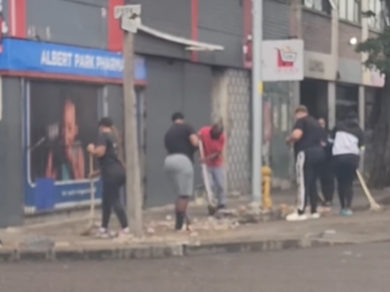 A group of people clean up a street side in Durban